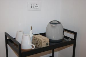 a black shelf with a tea pot and cups on it at La Sosta nel Borgo in Anguillara Sabazia