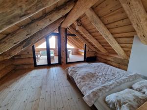 een slaapkamer op zolder met een bed en een groot raam bij Vila Vrhi in Pregrada