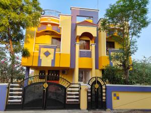 ティルチラーパッリにあるSunshine Villa & Homestayの黒門黄色の家