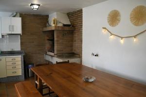 a kitchen with a wooden table and a brick fireplace at O Monteiriño in Arbo