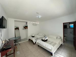 a bedroom with two beds and a table and a tv at Cactus in Puerto Baquerizo Moreno