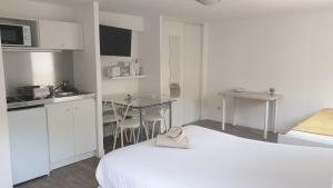 Zimmer mit einem Bett und einem Tisch sowie einer Küche in der Unterkunft Tours, Touraine et Chateaux de la Loire in Fondettes