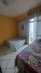 1 dormitorio con 2 camas y ventana en Apartamento 2 Quartos Praia do Morro, en Guarapari
