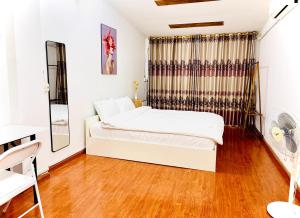 a bedroom with a white bed and a window at Liu homestay in Nà Phia