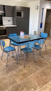 une table bleue avec des chaises et une assiette de gâteau. dans l'établissement La Tapie de Bouchet, à Arles