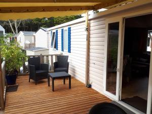 a patio with chairs and a table on a deck at Camping Quiberon Mobilhomes bord de mer Conguel in Quiberon