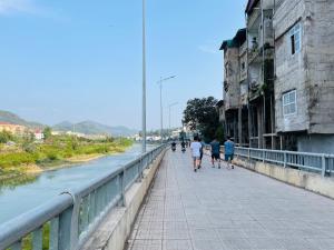 Eine Gruppe von Menschen, die auf einer Brücke über einen Fluss laufen in der Unterkunft Liu homestay in Nà Phia