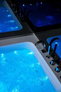 a bath tub with blue water in a room at Hey Suite Luxury GuestHouse Roma-Trastevere in Rome