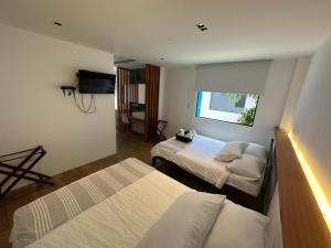 a hotel room with two beds and a television at Cactus in Puerto Baquerizo Moreno