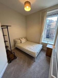 a small bedroom with a bed and a window at Apartment 381 in Jesmond