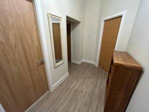 a hallway with a wooden door and a wooden floor at Apartment 381 in Jesmond