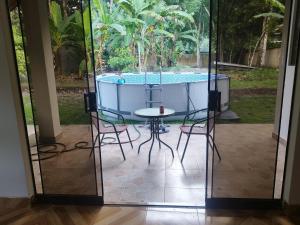 un patio con mesa, sillas y piscina en Villa Elena, en Tingo María