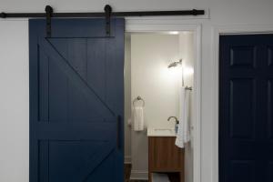 a blue sliding door in a bathroom with a sink at Spacious Bates-Hendricks Home ~ 5 Min to Lucas Oil in Indianapolis