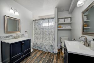 a bathroom with a shower and two sinks and a toilet at Spacious Bates-Hendricks Home ~ 5 Min to Lucas Oil in Indianapolis +68 photos
