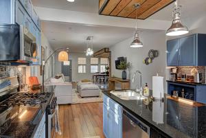 a kitchen with blue cabinets and a living room at Spacious Bates-Hendricks Home ~ 5 Min to Lucas Oil in Indianapolis
