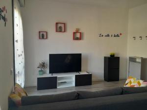 sala de estar con sofá y TV de pantalla plana en Appartamento a Ravenna - 100 metri dalla spiaggia, en Lido Adriano