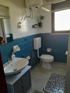 y baño con lavabo y aseo. en Appartamento a Ravenna - 100 metri dalla spiaggia, en Lido Adriano