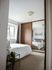 a bedroom with a bed and a large mirror at Urban Oasis in Abbey Wood