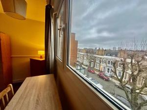 a window with a table and a view of a city at Mile End House in London