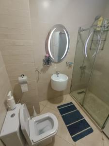 ein Bad mit einem WC, einem Waschbecken und einer Dusche in der Unterkunft Appartement de vacances BERALMAR CHEZ HOUDA in Asilah