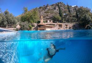 a woman swimming in the water in a pool at Malathiros Traditional Villas in Maláthiros