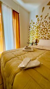 a yellow bed with a pair of shoes on it at Casa Lilla in Monreale