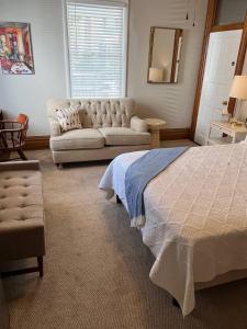 a bedroom with a bed and a couch at Spacious Suite Wkitchenette in Ligonier