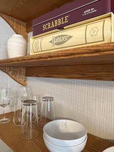 uma prateleira de madeira com óculos e uma caixa. em Spacious Suite Wkitchenette em Ligonier