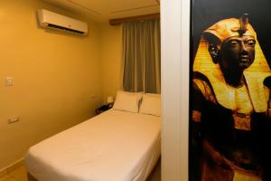 ein Schlafzimmer mit einem Bett und ein Gemälde einer Frau in der Unterkunft Giza Pyramids View Inn in Kairo