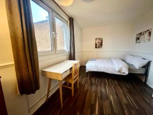 a small bedroom with a bed and a window at Mile End House in London