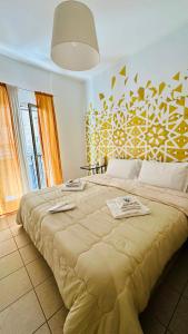 a bedroom with a large bed with a yellow patterned wall at Casa Lilla in Monreale