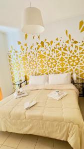 sypialnia z dużym łóżkiem i żółto-białą ścianą w obiekcie Casa Lilla w mieście Monreale