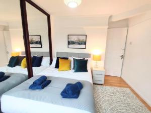 Dos camas en una habitación con dos almohadas azules. en Sigma Palace Free Parking en Longbenton