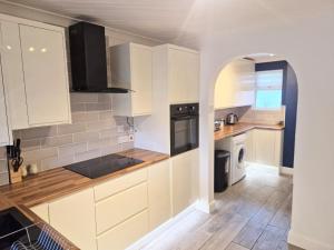 een keuken met witte kasten en een houten vloer bij Sigma Palace Free Parking in Longbenton