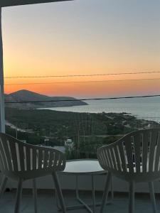 - deux chaises et une table sur un balcon avec vue sur le coucher du soleil dans l'établissement Duplex Blue Lagoon, à Bizerte