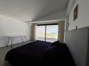 a bedroom with a bed and a large window at Duplex Blue Lagoon in Bizerte