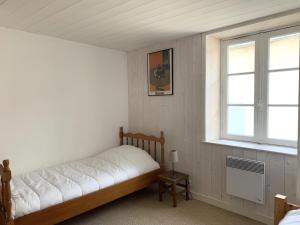 1 dormitorio con cama y ventana en Maison de vacances BERENICE à St Martin de Ré, en Saint-Martin-de-Ré