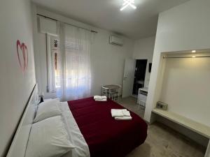 a bedroom with a bed with two towels on it at La Piazza BeB in Tropea