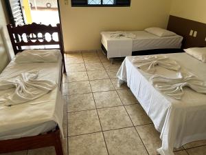 three beds in a room with a tiled floor at ADM HOTEL in JataÃ­