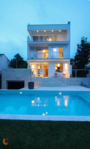 una casa con piscina frente a ella en Villa Terra Rossa Borik, en Rovinj