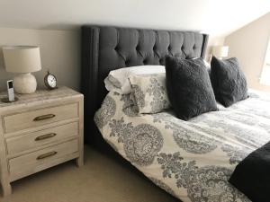 - une chambre avec un lit doté d'oreillers et d'une table de nuit dans l'établissement Beautiful Luxury Suite A & B of Shorewood Home, à Shorewood