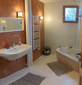 a bathroom with a sink and a bath tub and a tubermott at Ecolodge La Belle Verte in Saint-Mʼhervé
