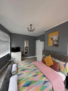 a bedroom with a large bed and a chandelier at Herbies Stay in Southend-on-Sea