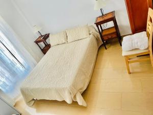 a bed in a room with a table and a chair at Acantilados De Maro in Maro