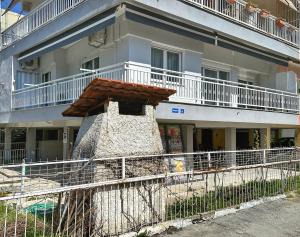 a building with a fence in front of it at Eden Suite Paralia in Paralia Katerinis
