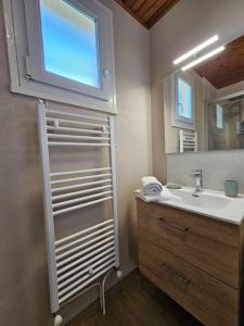 un bagno con lavandino e specchio di Le Beau Repère a Beaurepaire Altre 19 foto