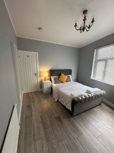 a bedroom with a bed and a chandelier at Herbies Stay in Southend-on-Sea