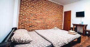 a bedroom with a bed against a brick wall at Fortetsya in Umanʼ