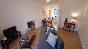 a living room with a couch and a table at Appartement confort deux Etoiles in Dole