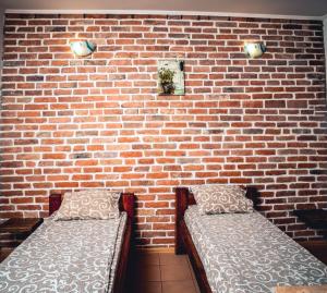 dwa łóżka przed ścianą z cegły w obiekcie Fortetsya w mieście Humań